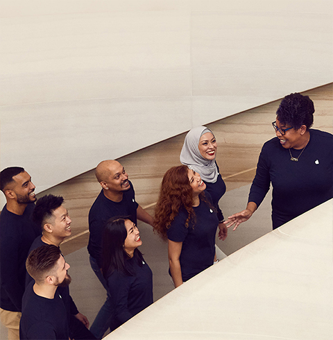 Medarbejdere på vej op ad en trappe i en Apple Store.