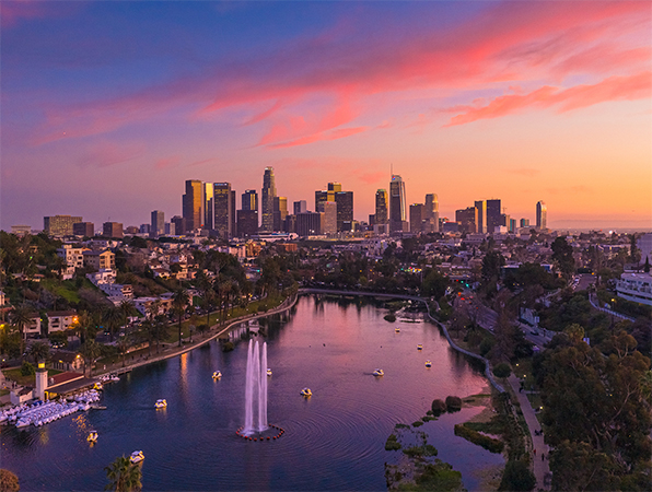 Letecký pohled na mrakodrapy v Los Angeles s parkem a jezerem v popředí.