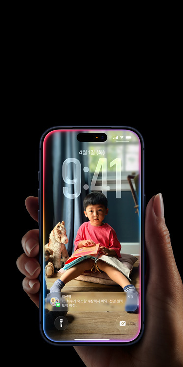개인 맞춤 설정한 잠금 화면에 메시지 팝업이 떠 있는 iPhone 17 Pro를 손으로 쥐고 있는 모습.