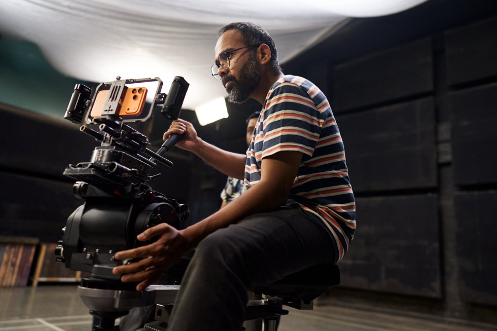 iPhone 17 Pro Max on a camera rig is set up in a studio environment, with a person standing nearby.