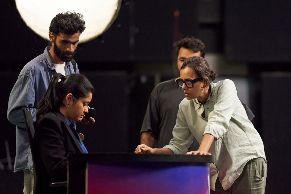 On set, Dhritisree Sarkar and her crew discuss a scene with an actor.