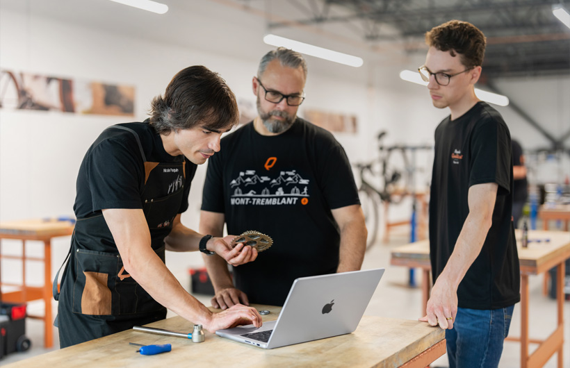 Nicolas Paquin, pelatih di Bicycles Quilicot, menggunakan MacBook Pro untuk mengakses materi program sertifikasi mekanik sepeda gratis perusahaan.